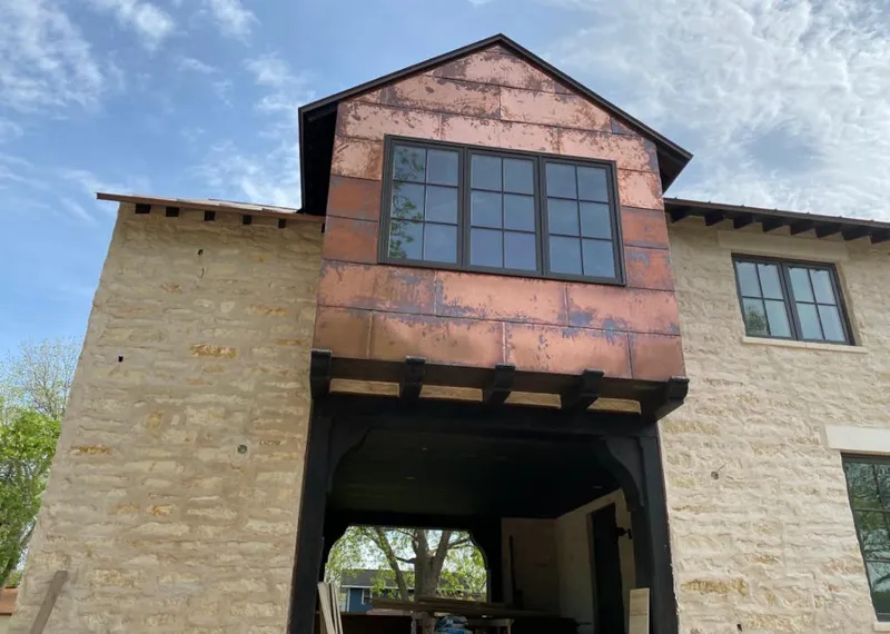 Copper metal panel facade on a stone building for Skylight Installation in Jasper